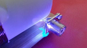 SO-239 attached with UV glue. (Glue is fluorescing)